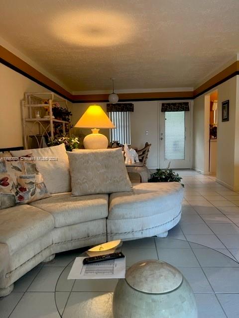 living room featuring ornamental molding and light tile floors