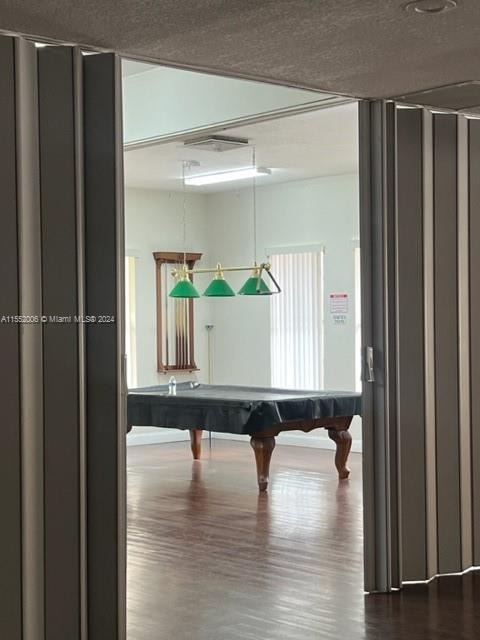 misc room with a textured ceiling, billiards, and dark hardwood / wood-style flooring