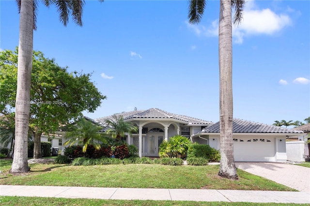 mediterranean / spanish home with a front lawn and a garage