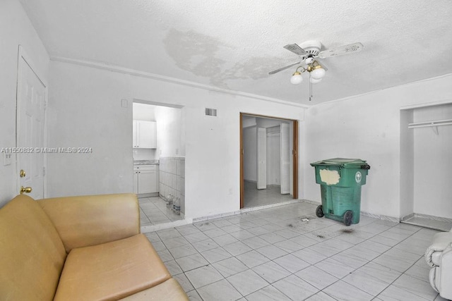 spare room with light tile floors, a textured ceiling, and ceiling fan