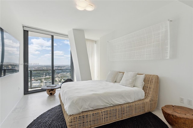 tiled bedroom featuring a wall of windows and multiple windows