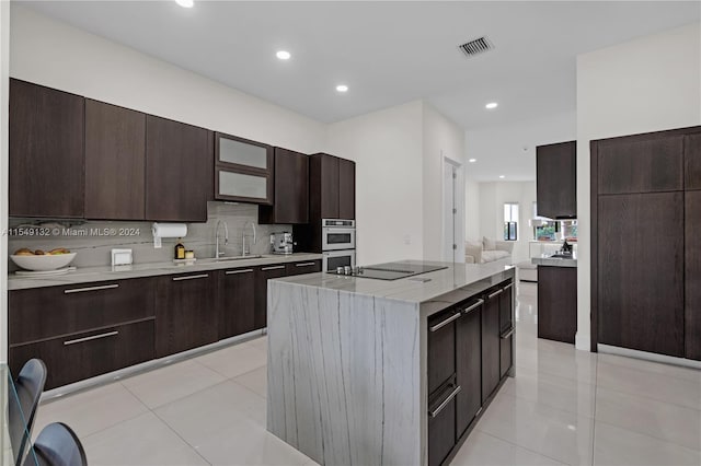 kitchen with light tile floors, a center island, backsplash, and dark brown cabinetry