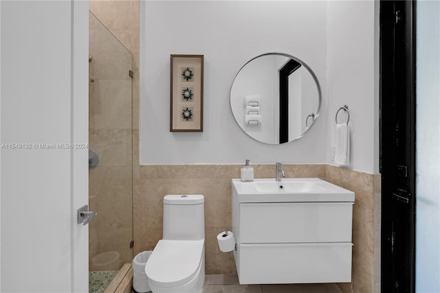 bathroom with tile walls, walk in shower, toilet, and large vanity