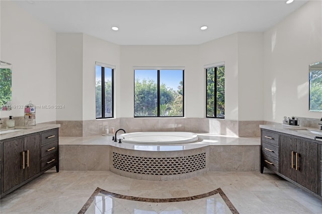 bathroom featuring tiled tub, tile floors, and vanity with extensive cabinet space