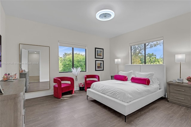 bedroom with multiple windows and dark hardwood / wood-style flooring