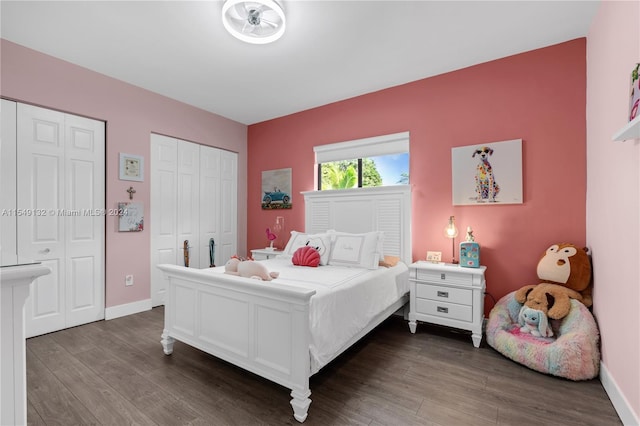 bedroom featuring two closets and dark hardwood / wood-style flooring