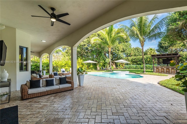 view of patio featuring an outdoor living space, a pergola, a swimming pool with hot tub, and ceiling fan