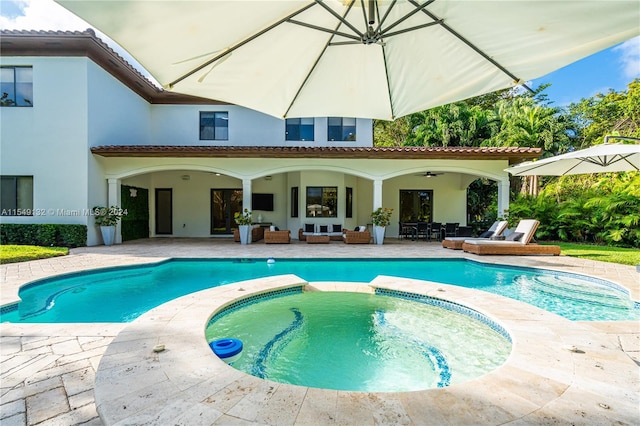 view of pool featuring an in ground hot tub, ceiling fan, and a patio area