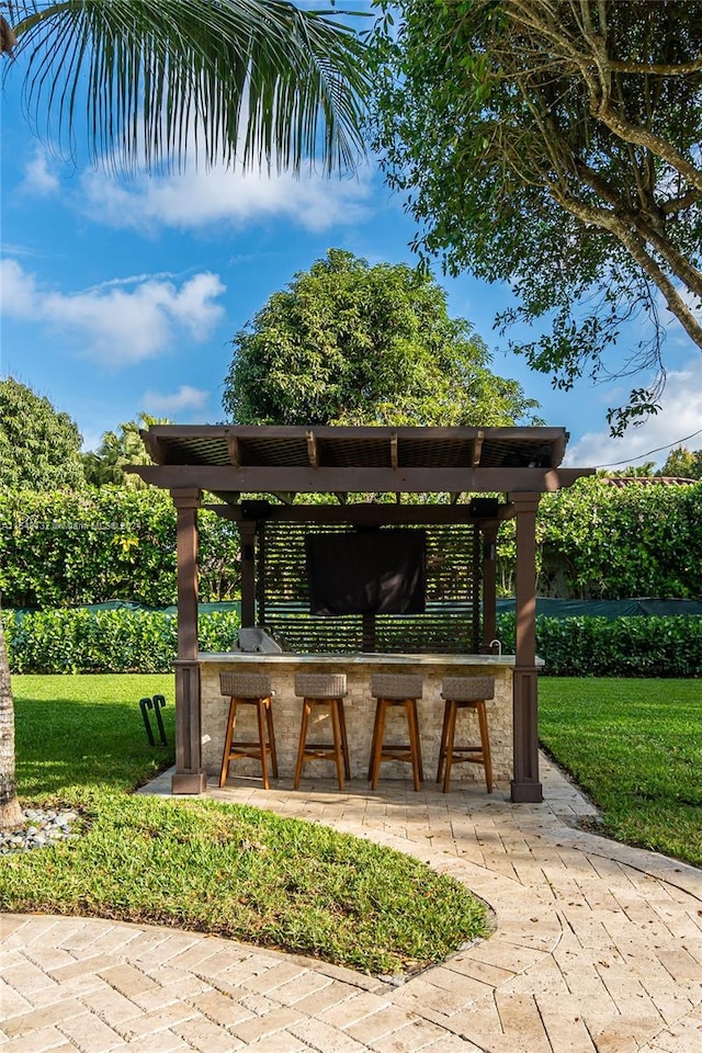 view of home's community with a yard, a pergola, and an outdoor bar