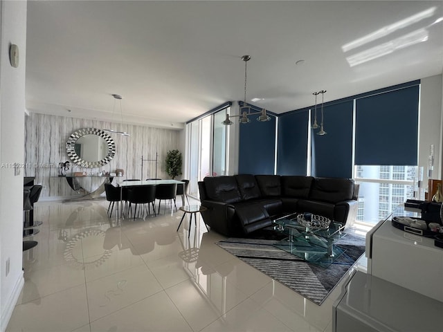 tiled living room featuring a chandelier and expansive windows