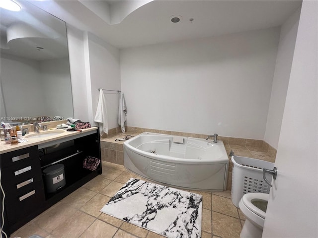 bathroom featuring a tub, toilet, vanity with extensive cabinet space, and tile flooring