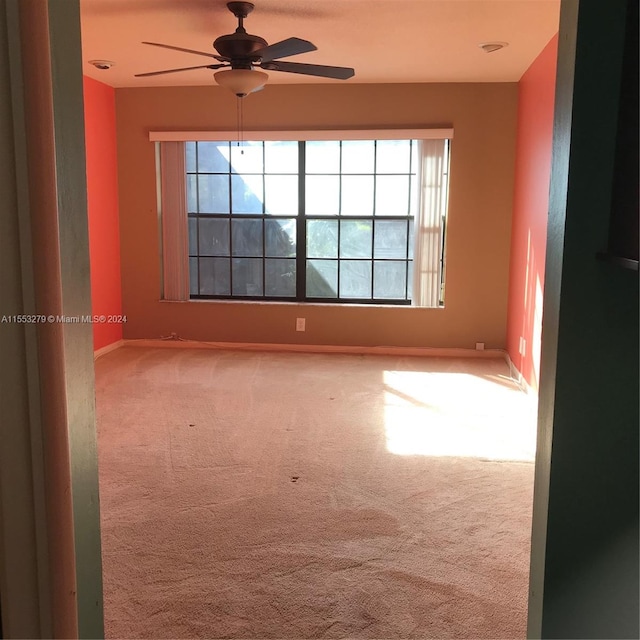 carpeted spare room with ceiling fan