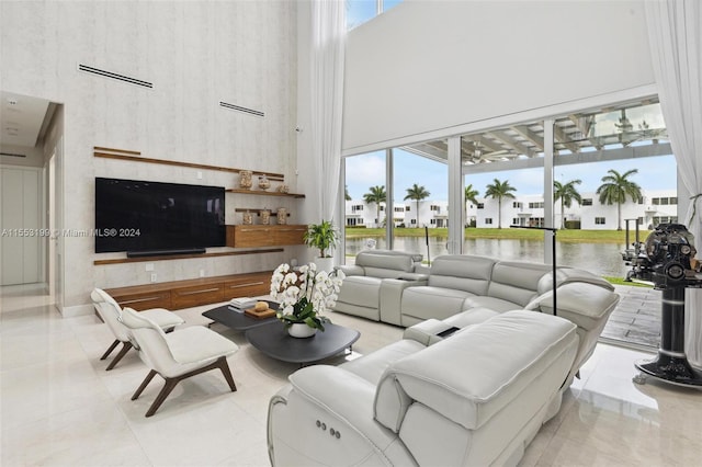 living room with light tile flooring and a towering ceiling