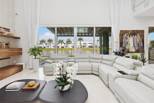 tiled living room featuring a high ceiling and a healthy amount of sunlight