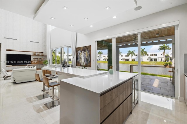 kitchen featuring a water view, a center island, and light tile floors