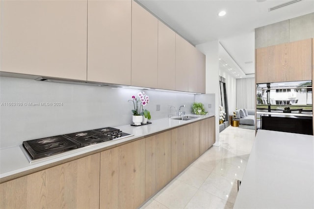 kitchen with light tile flooring, double wall oven, light brown cabinetry, and sink