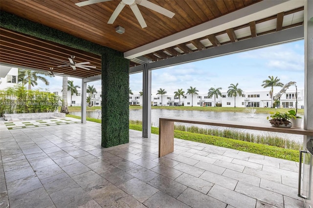 view of patio / terrace featuring ceiling fan and a water view