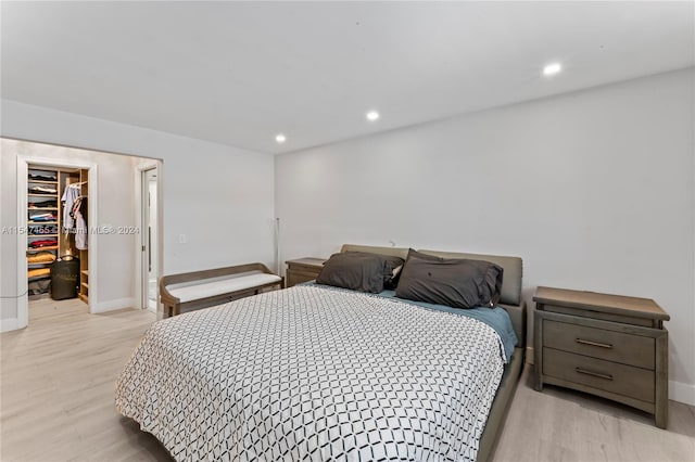 bedroom with a closet, a spacious closet, and light wood-type flooring