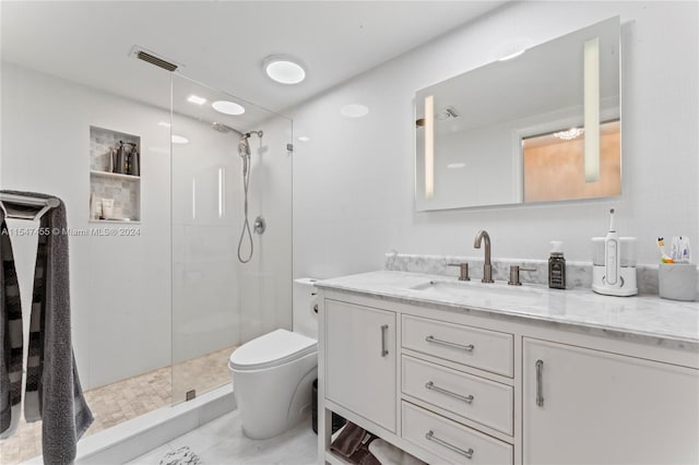 bathroom featuring tile floors, vanity, toilet, and tiled shower