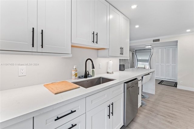 kitchen with white cabinets, sink, light hardwood / wood-style floors, and dishwasher