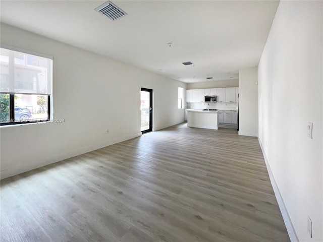 unfurnished living room with plenty of natural light and wood-type flooring