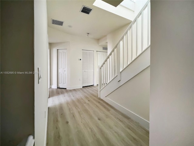 entryway with a skylight and light hardwood / wood-style floors