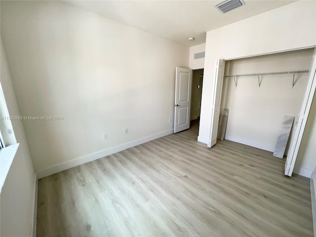 unfurnished bedroom featuring light hardwood / wood-style floors and a closet