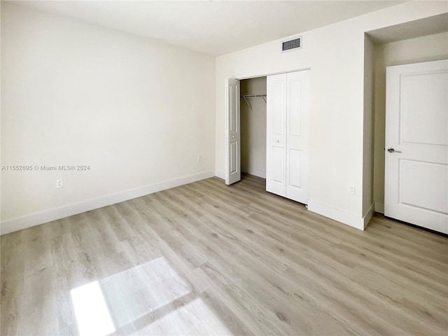 unfurnished bedroom featuring light hardwood / wood-style floors and a closet