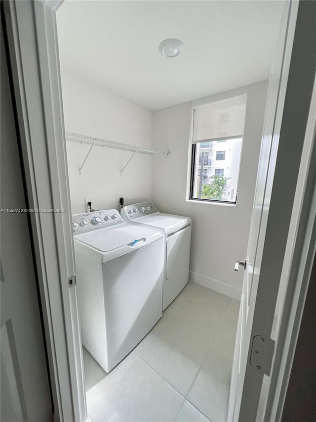 laundry room featuring washer and dryer, electric dryer hookup, and light tile floors