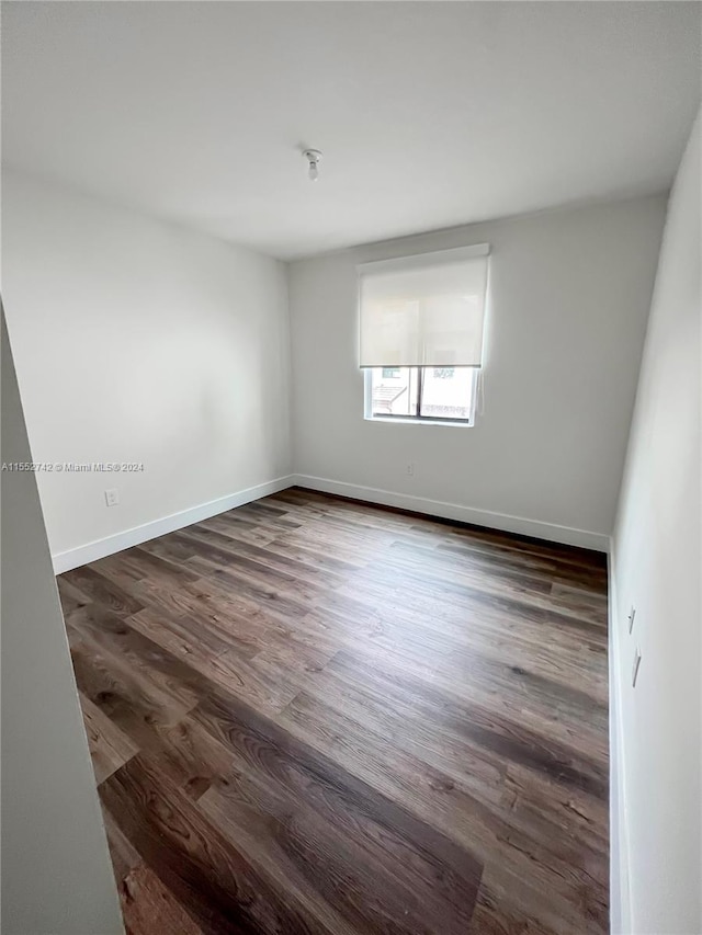 unfurnished room featuring dark wood-type flooring