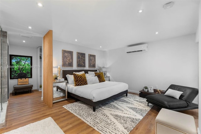 bedroom featuring light hardwood / wood-style flooring and a wall unit AC