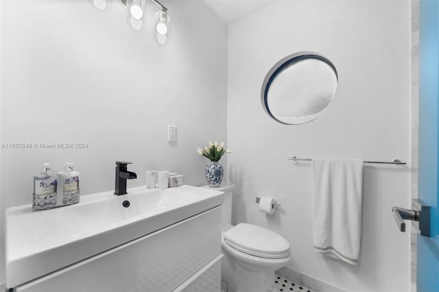 bathroom featuring tile patterned flooring, toilet, and vanity