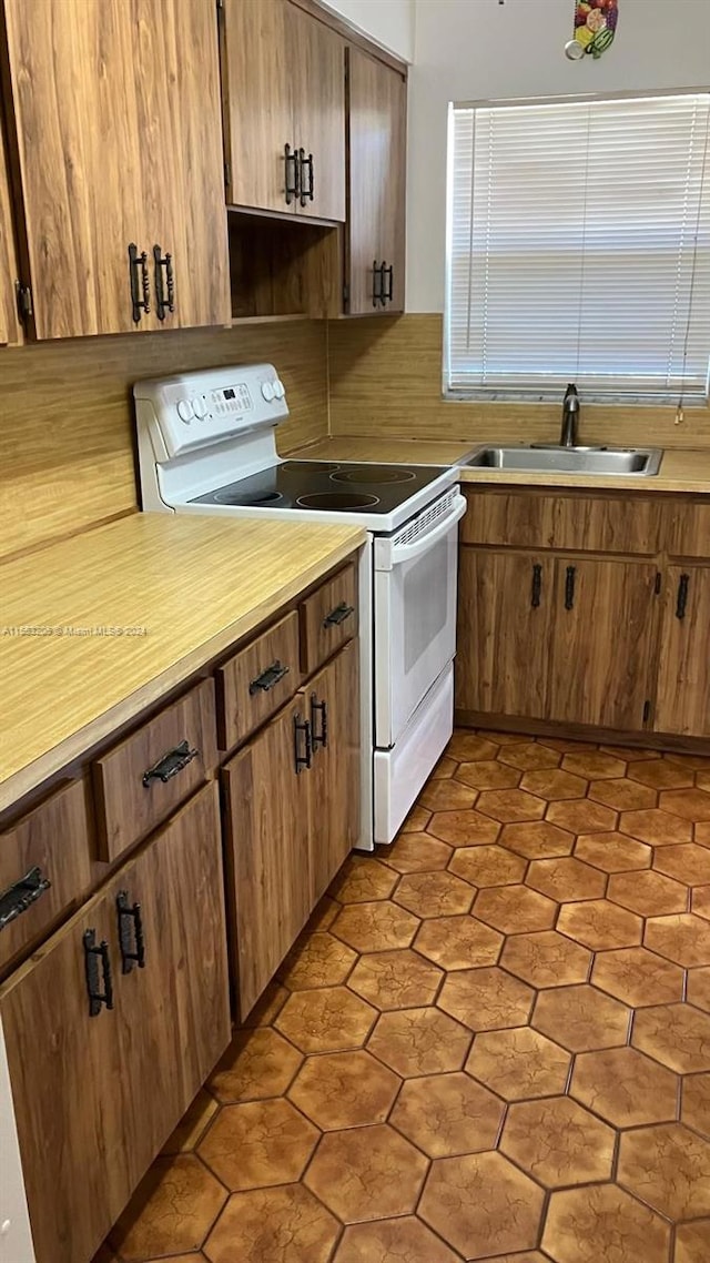 kitchen featuring white range with electric stovetop and sink