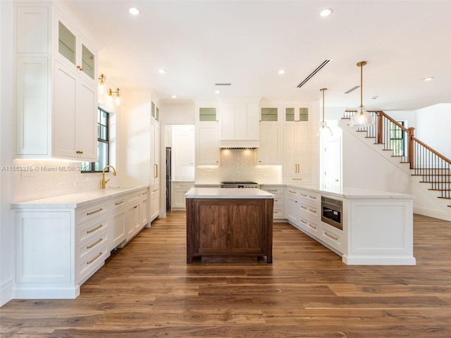 kitchen featuring dark hardwood / wood-style floors, a center island, and white cabinetry