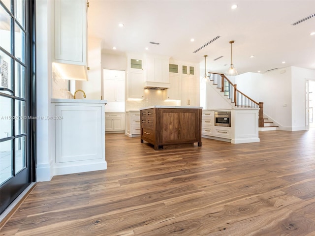 kitchen with white cabinets, a center island, decorative light fixtures, and plenty of natural light