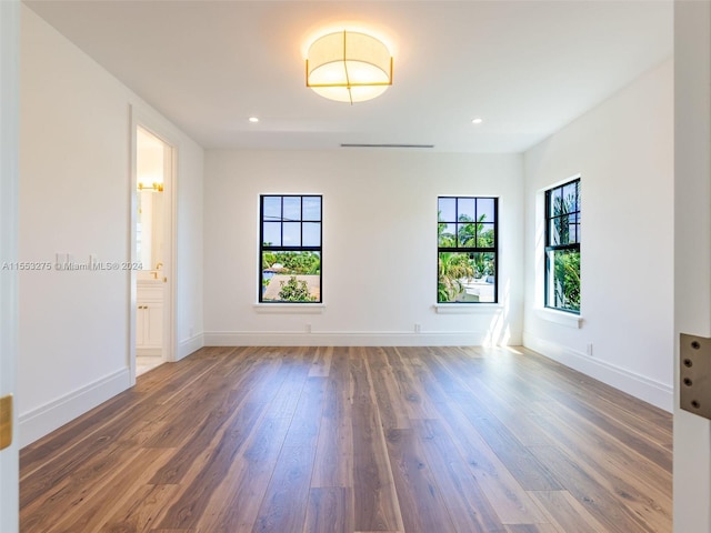 unfurnished room with dark hardwood / wood-style flooring and plenty of natural light