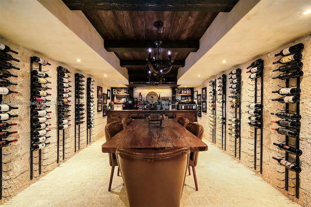 wine room featuring beam ceiling, light colored carpet, and wooden ceiling