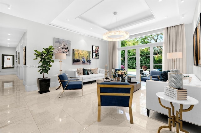 living room with a raised ceiling and french doors