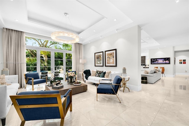 living room with a raised ceiling and french doors