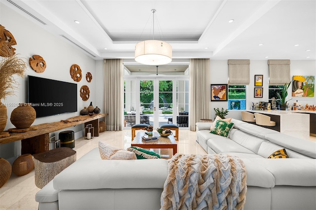 living room featuring french doors and a tray ceiling