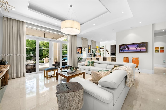 living room featuring a raised ceiling and french doors