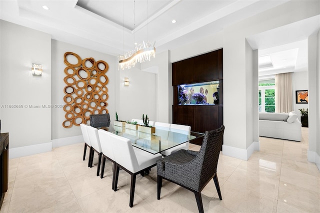 dining space with a raised ceiling