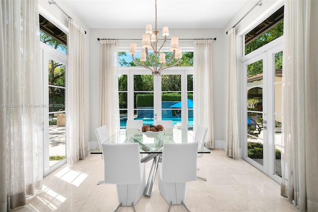 sunroom with a chandelier and french doors