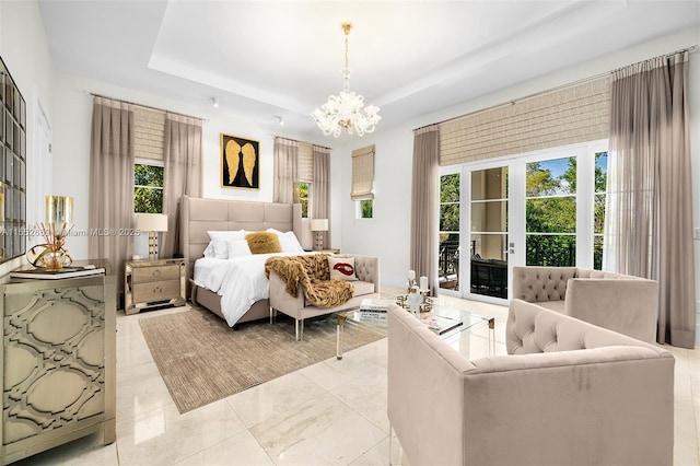 bedroom with a chandelier, access to outside, and a tray ceiling