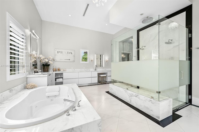 bathroom featuring vanity, a healthy amount of sunlight, and plus walk in shower