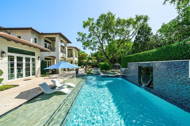 view of pool featuring a patio area, an in ground hot tub, and pool water feature