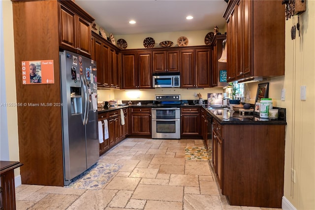 kitchen with light tile floors, appliances with stainless steel finishes, dark brown cabinets, and sink