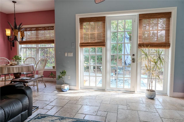 doorway to outside with an inviting chandelier and light tile floors