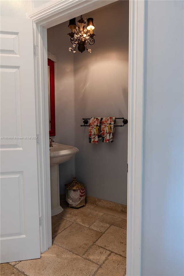 bathroom featuring tile floors and a notable chandelier