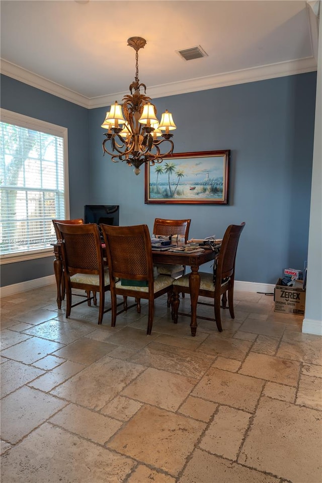 tiled dining room featuring a chandelier and ornamental molding